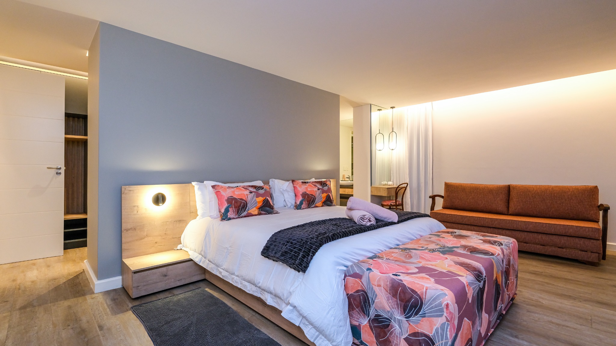 Bedroom with patterned bedding and timber furniture