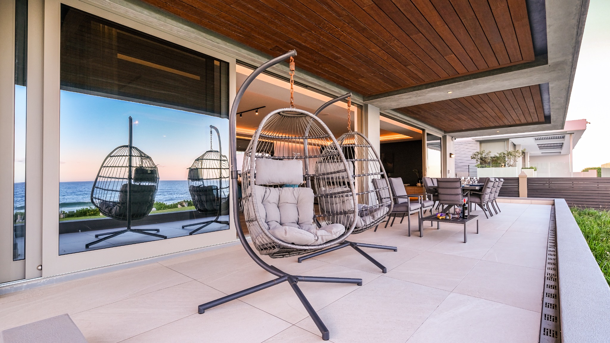 Covered terrace with hanging chairs and outdoor dining